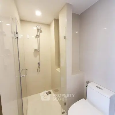 Modern bathroom with glass shower enclosure and sleek fixtures