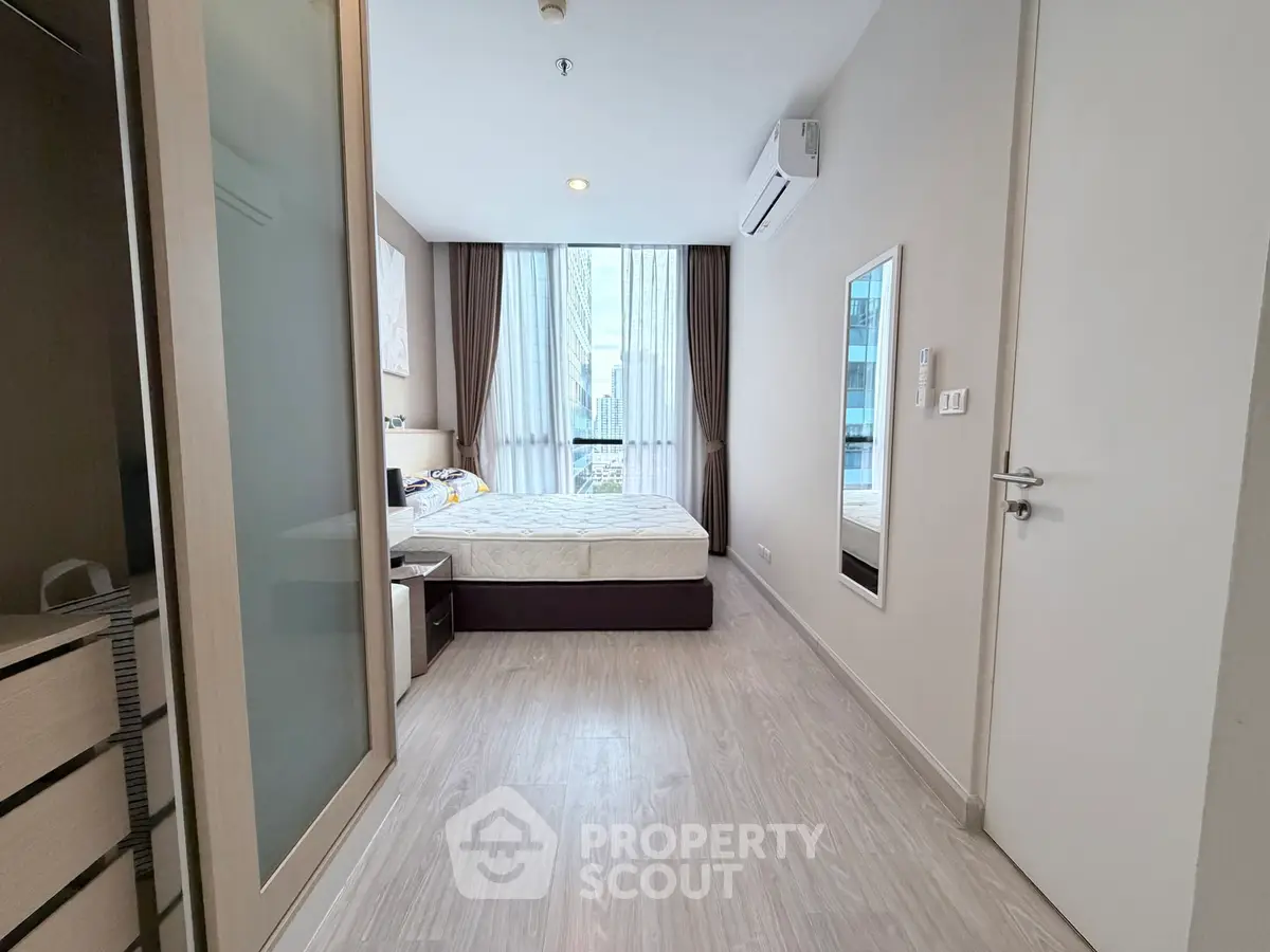 Modern bedroom with large window and city view in a stylish apartment