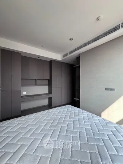 Spacious bedroom with built-in wardrobe and modern design in a luxury apartment.
