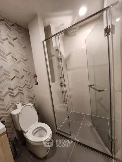 Modern bathroom with glass shower enclosure and stylish tile design.