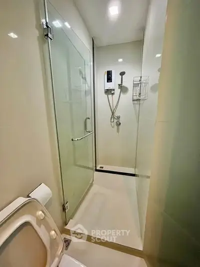 Modern bathroom with glass shower enclosure and sleek fixtures