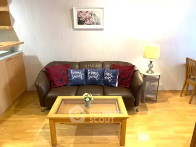 Cozy living room with stylish sofa, decorative pillows, and elegant wooden coffee table.