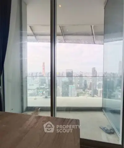Stunning city view from modern high-rise apartment balcony with glass railing.