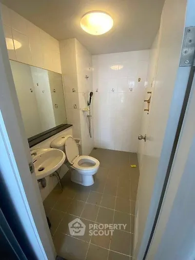 Modern bathroom with sleek fixtures and large mirror in a contemporary apartment.