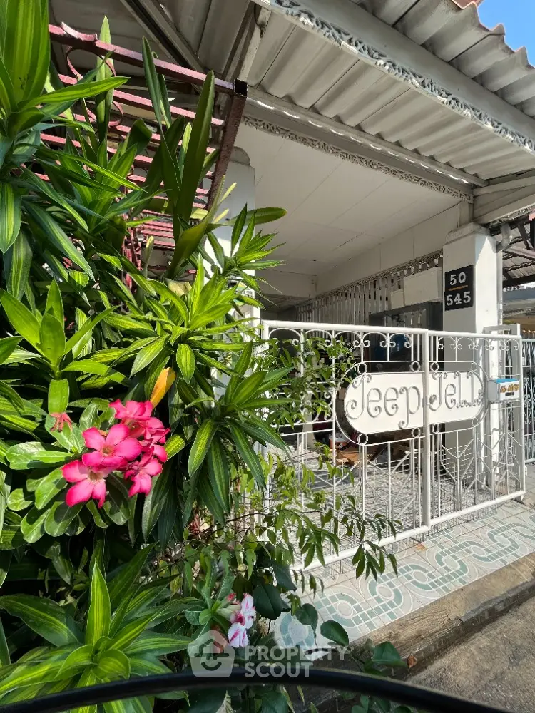 Charming single-story home with lush garden and secure gated entrance, boasting a cozy covered carport and inviting tropical ambiance.