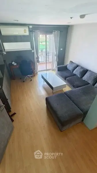Spacious living room with modern furniture and balcony access, perfect for relaxation and entertaining.