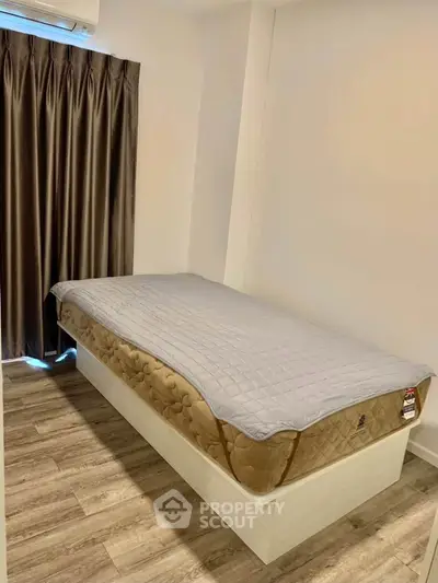 Cozy bedroom with single bed and elegant curtains, perfect for a minimalist lifestyle.