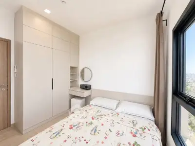 Bright and cozy bedroom with large window and modern furnishings
