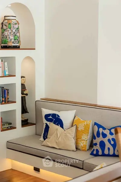 Charming living room nook with cozy seating and decorative shelves.