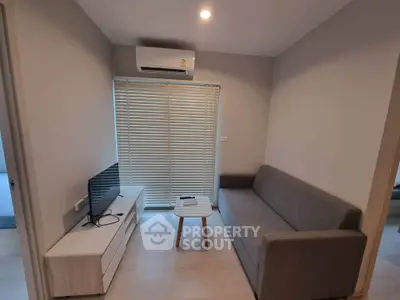 Cozy living room with modern sofa and TV, perfect for relaxation.