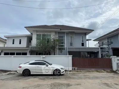 Modern two-story house with white exterior and sleek car parked outside.
