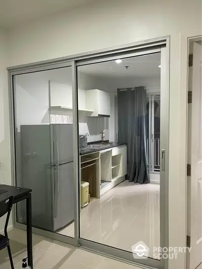 Modern kitchen with sleek design and glass sliding doors in a stylish apartment.