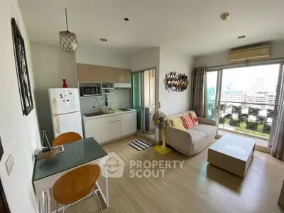 Modern open-plan living room with kitchen, featuring city view and stylish decor.