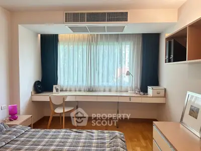 Stylish bedroom with large window and built-in desk, perfect for modern living.