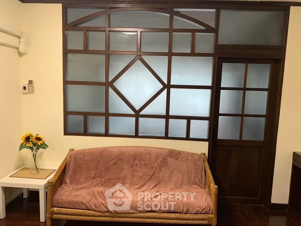 Charming living room with unique wooden window design and cozy seating area.