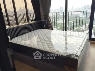 Spacious bedroom with city view and large windows in modern apartment.