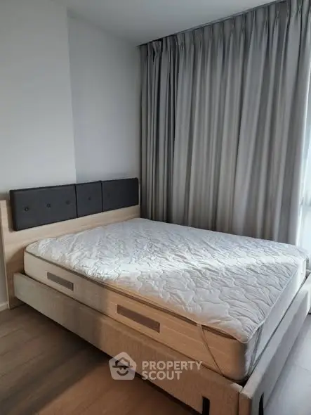 Modern bedroom with stylish bed and floor-to-ceiling curtains in a bright apartment.