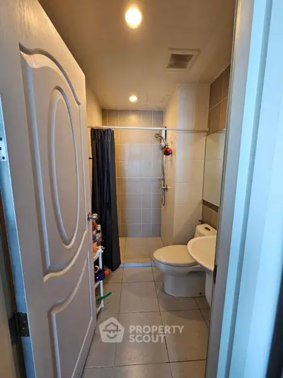 Compact modern bathroom with shower and sleek fixtures, ideal for urban living.