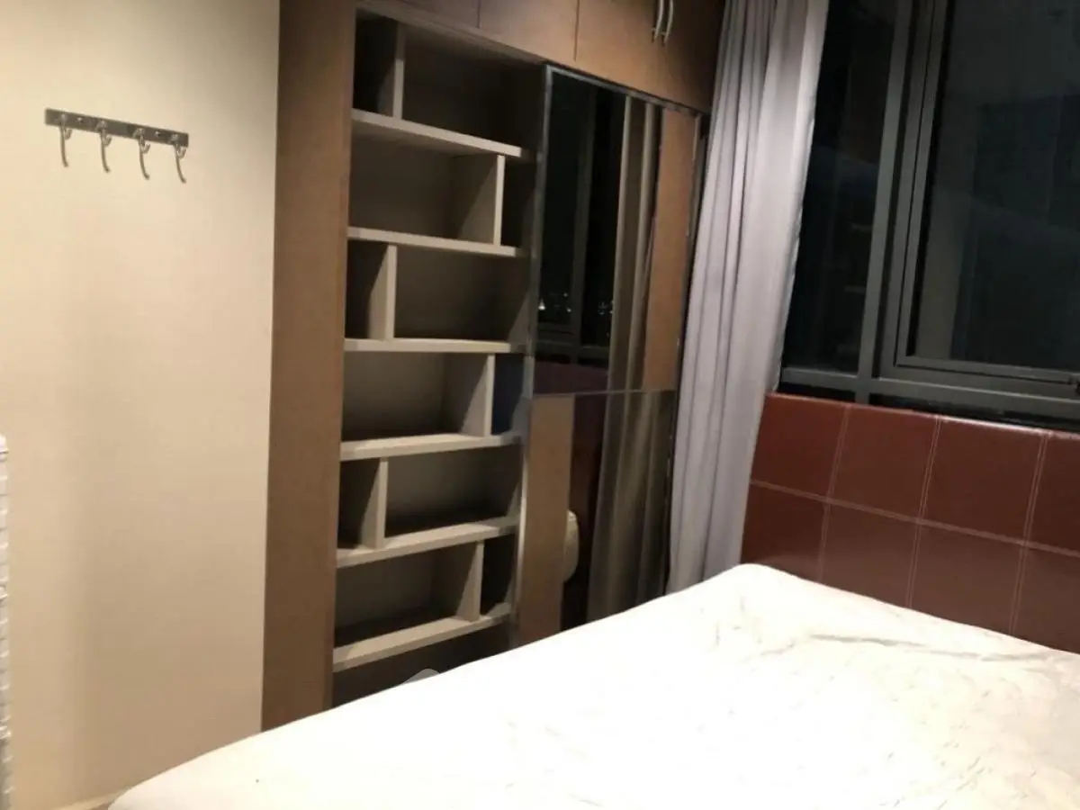 Cozy bedroom with built-in shelves and large window for natural light