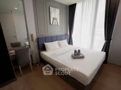Modern bedroom with elegant decor and large window in a stylish apartment.