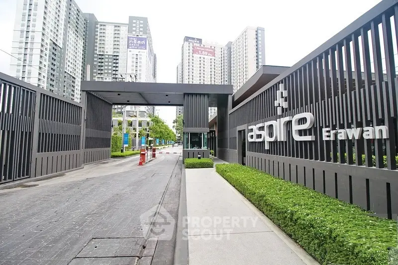Modern condominium entrance with sleek design and lush greenery at Aspire Erawan.