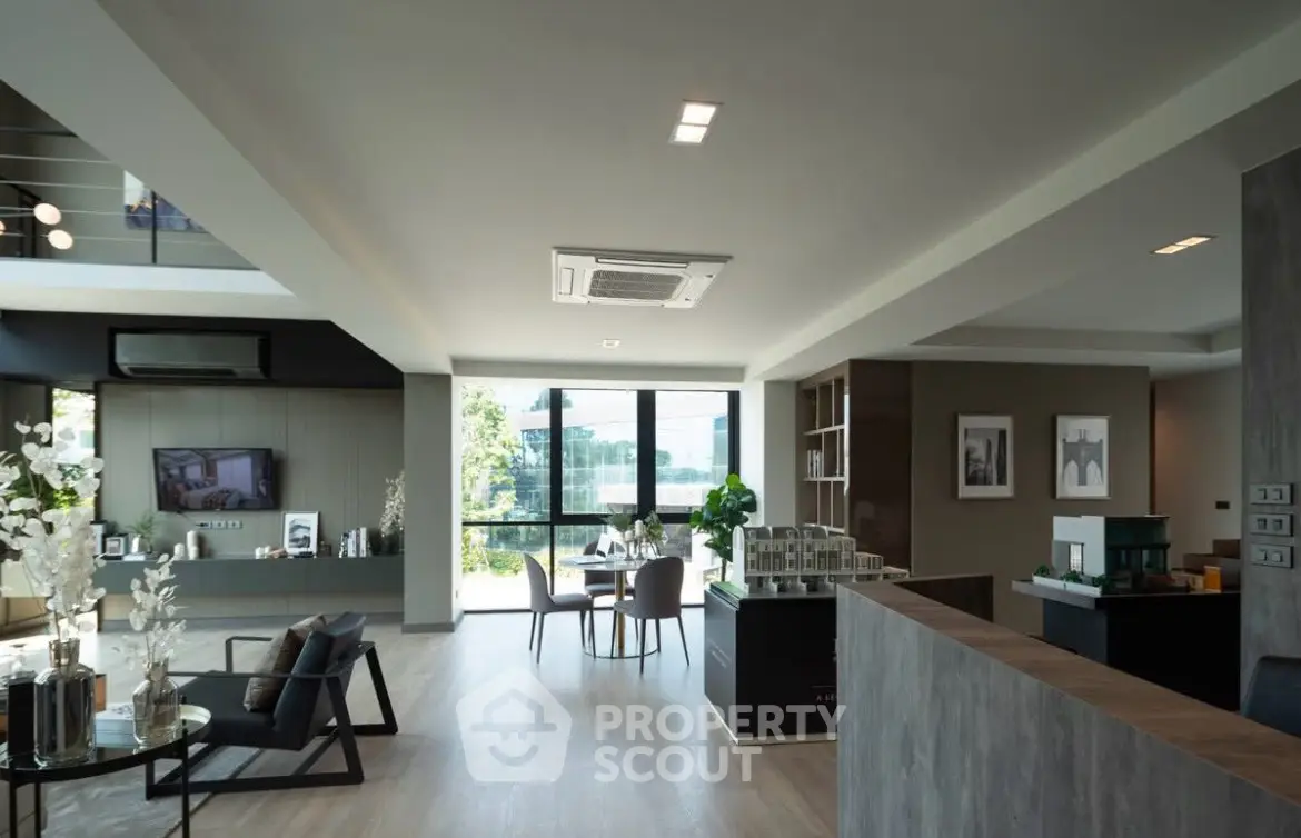 Spacious modern living room with open layout and large windows offering natural light.