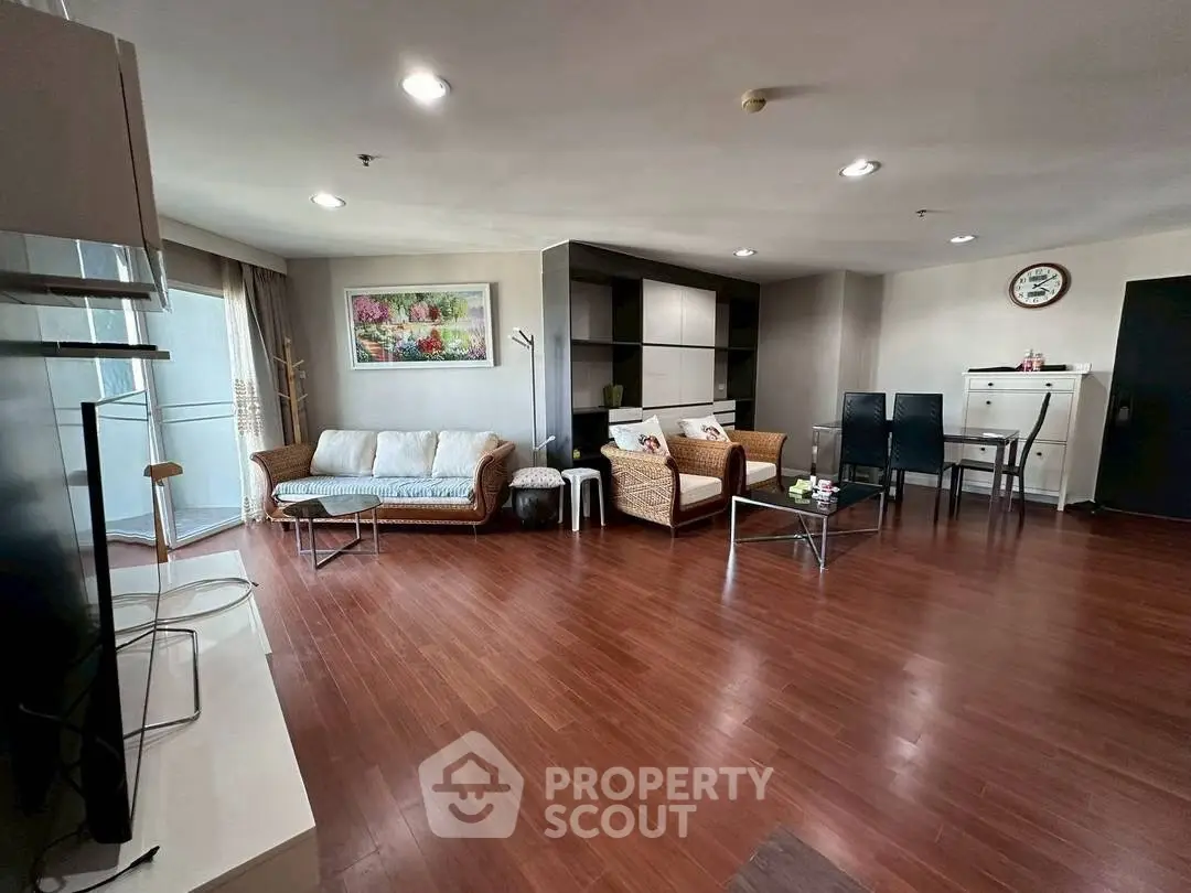 Spacious living room with wooden flooring and modern furniture in a stylish apartment.