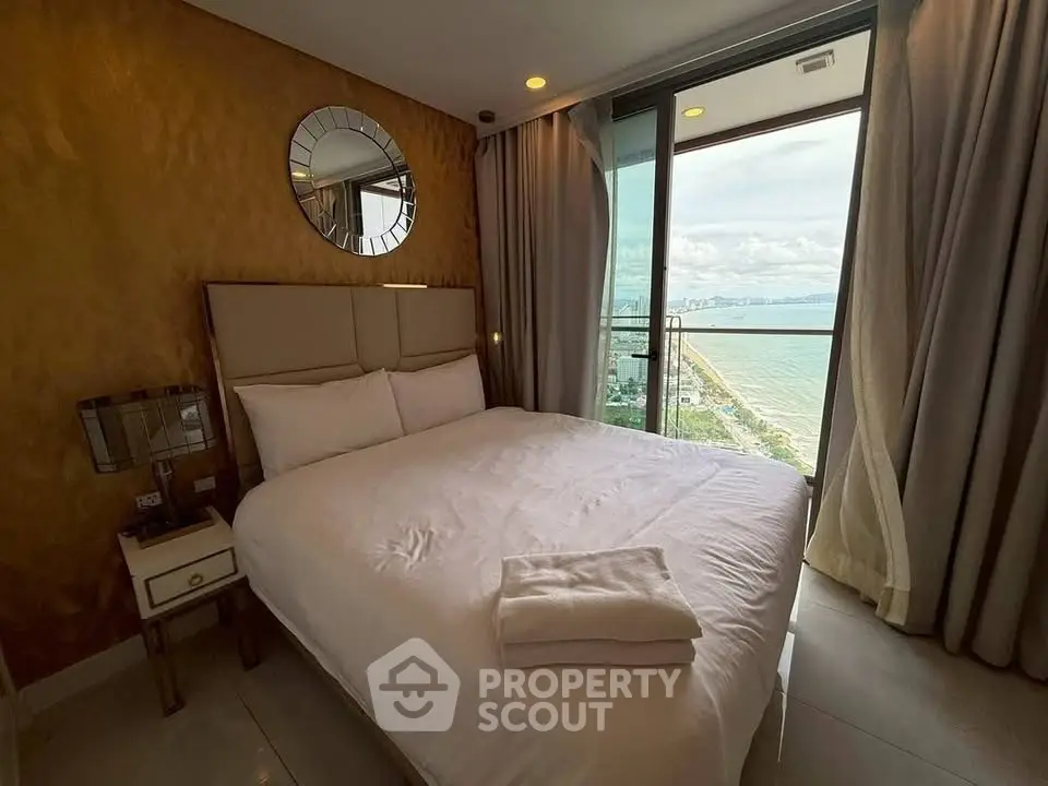 Luxurious bedroom with stunning ocean view and elegant decor in high-rise apartment.