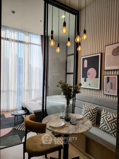 Modern apartment interior with stylish dining area and cozy bedroom separated by glass wall.