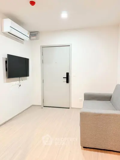 Modern minimalist living room with sleek sofa and wall-mounted TV