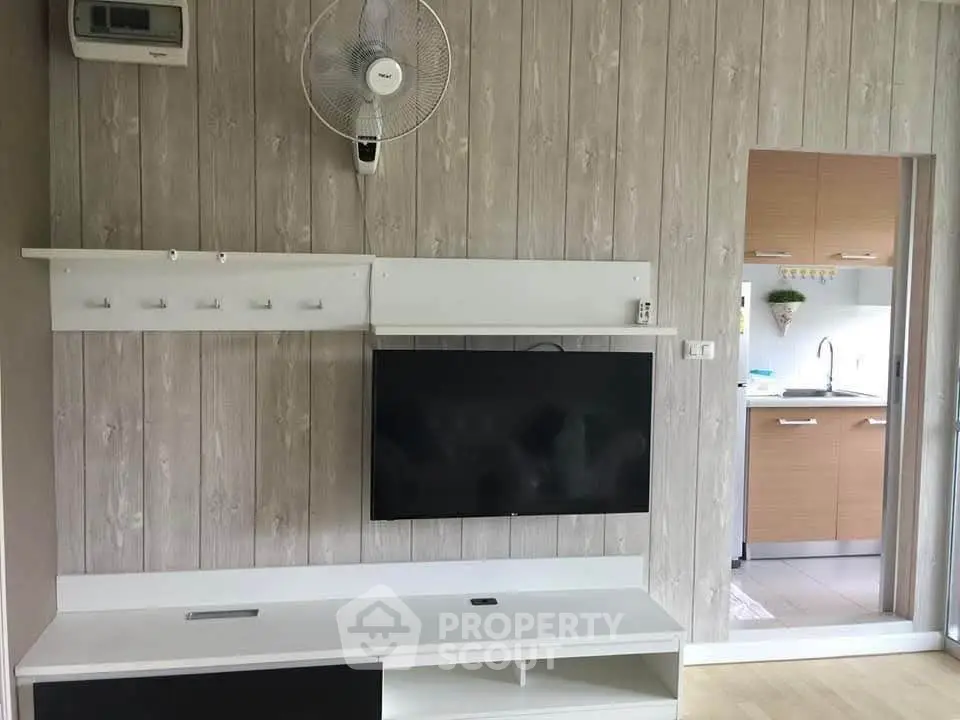 Modern living room with wall-mounted TV and open kitchen view