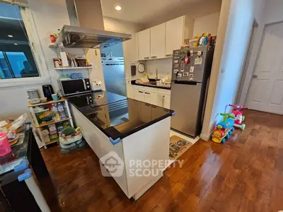 Modern kitchen with sleek appliances and wooden flooring, perfect for family cooking.