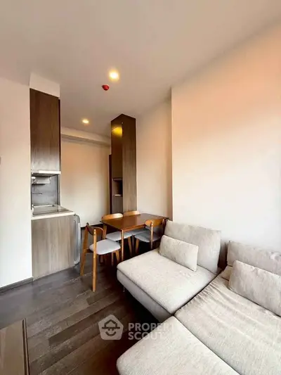 Modern living room with cozy sofa and dining area in open layout apartment.