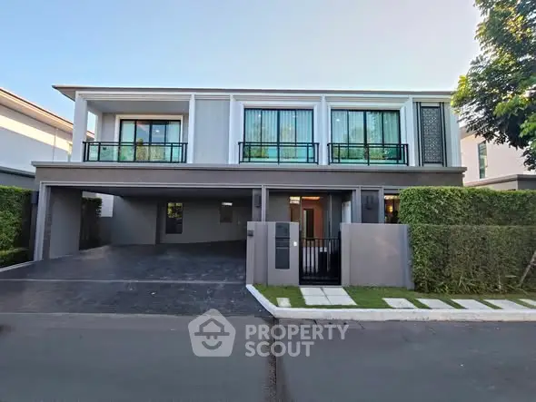 Modern two-story house with spacious driveway and lush greenery