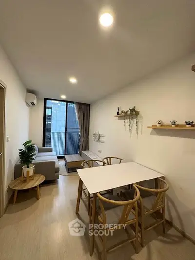 Modern living room with dining area and balcony view in a stylish apartment.