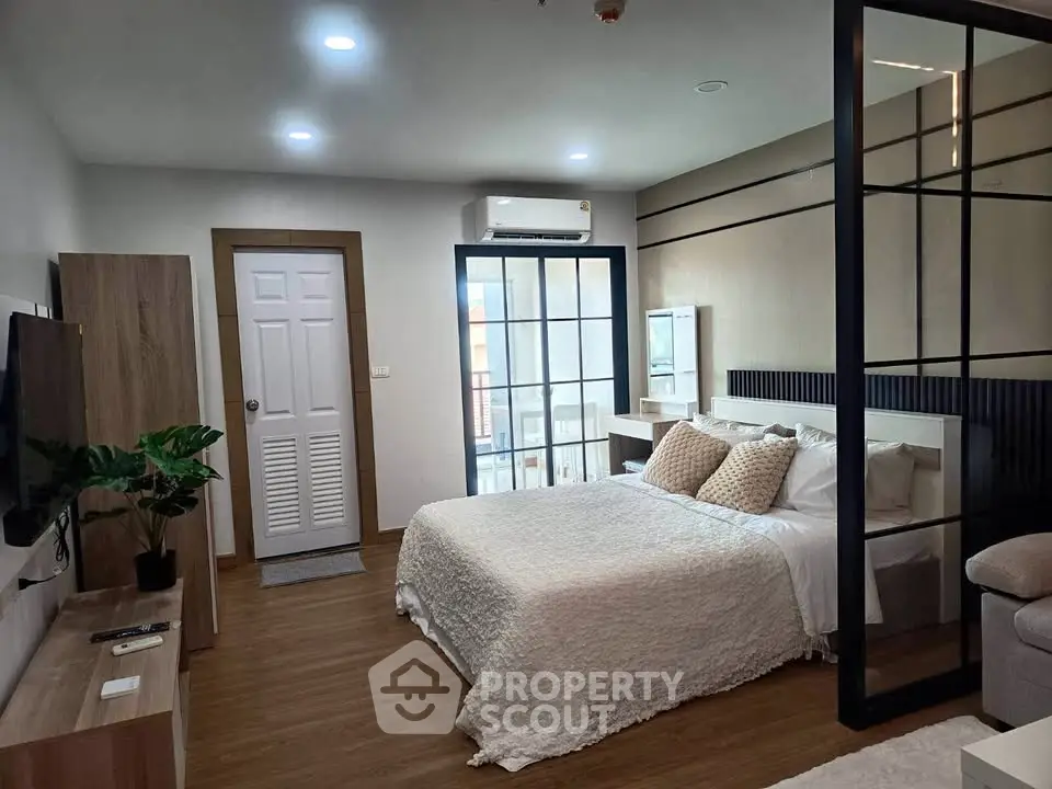 Modern bedroom with stylish decor and natural light, featuring a cozy bed and sleek furnishings.