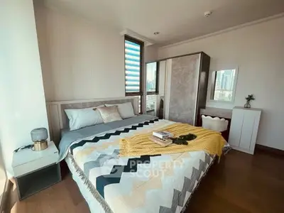 Modern bedroom with stylish decor and city view, featuring a cozy bed and elegant furnishings.