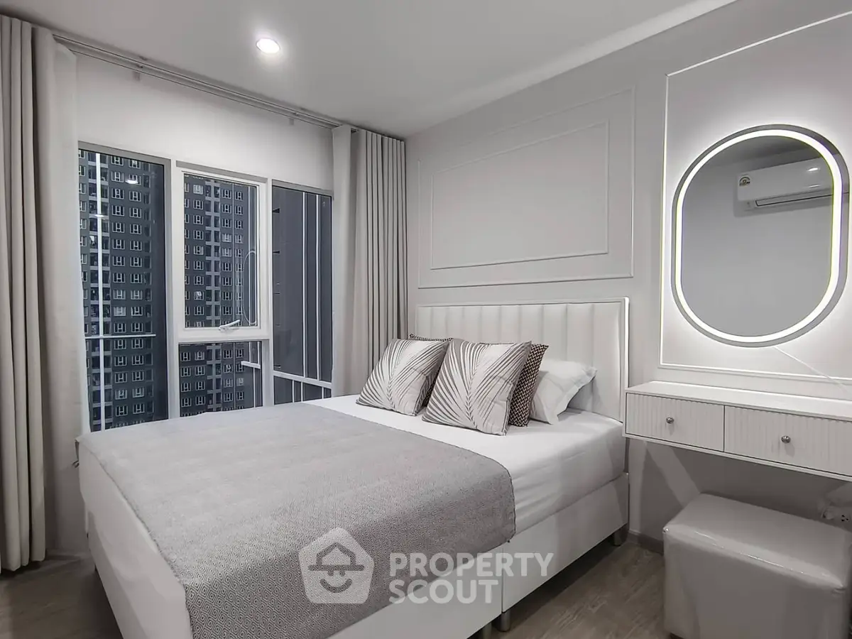 Modern bedroom with elegant decor and city view, featuring a cozy bed and stylish vanity.