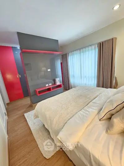 Modern bedroom with stylish decor and natural light, featuring a cozy bed and sleek design elements.