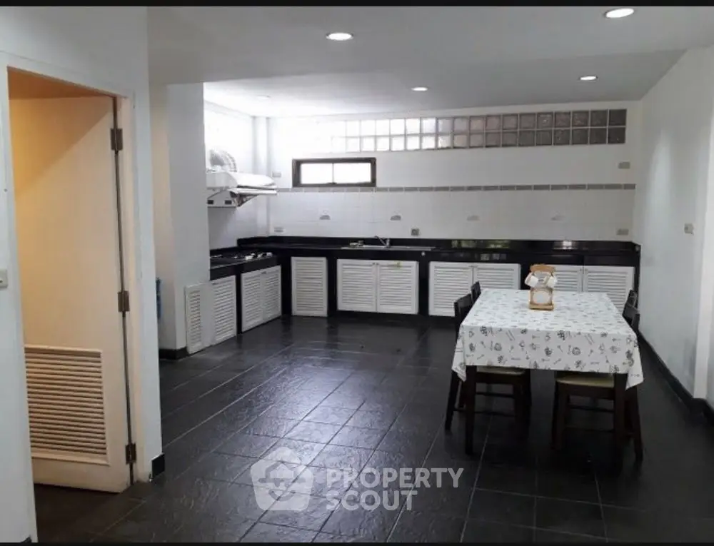Spacious kitchen with modern black countertops and dining area