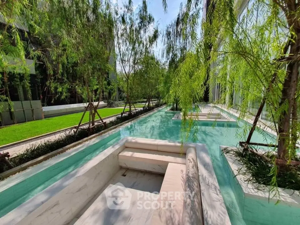 Luxurious outdoor pool area with lush greenery and modern seating, perfect for relaxation and leisure.