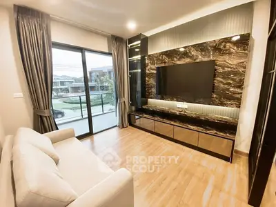 Modern living room with large TV, elegant decor, and spacious layout in a stylish home.