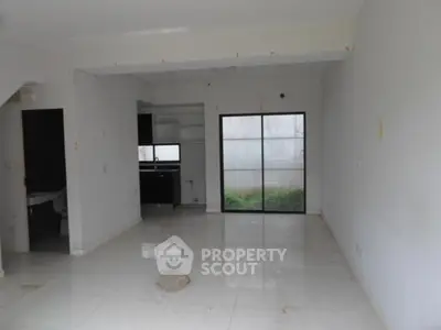 Spacious open-plan living area with large windows and modern kitchen