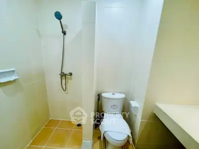 Modern bathroom with shower and toilet in a minimalist design.