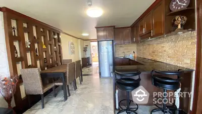 Elegant kitchen with dining area featuring marble floors and wooden cabinetry