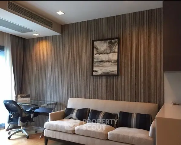 Modern living room with stylish sofa and workspace, featuring elegant decor and natural light.