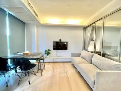 Modern living room with sleek design, featuring a cozy sofa, wall-mounted TV, and dining area with stylish chairs.