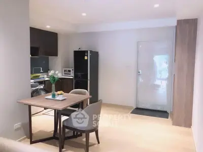 Modern open-layout kitchen and dining area with sleek furniture and appliances.