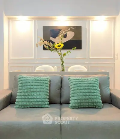 Stylish living room with modern decor and plush green cushions on a cozy sofa.