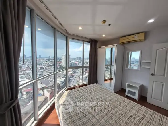Stunning bedroom with panoramic city views and modern furnishings.